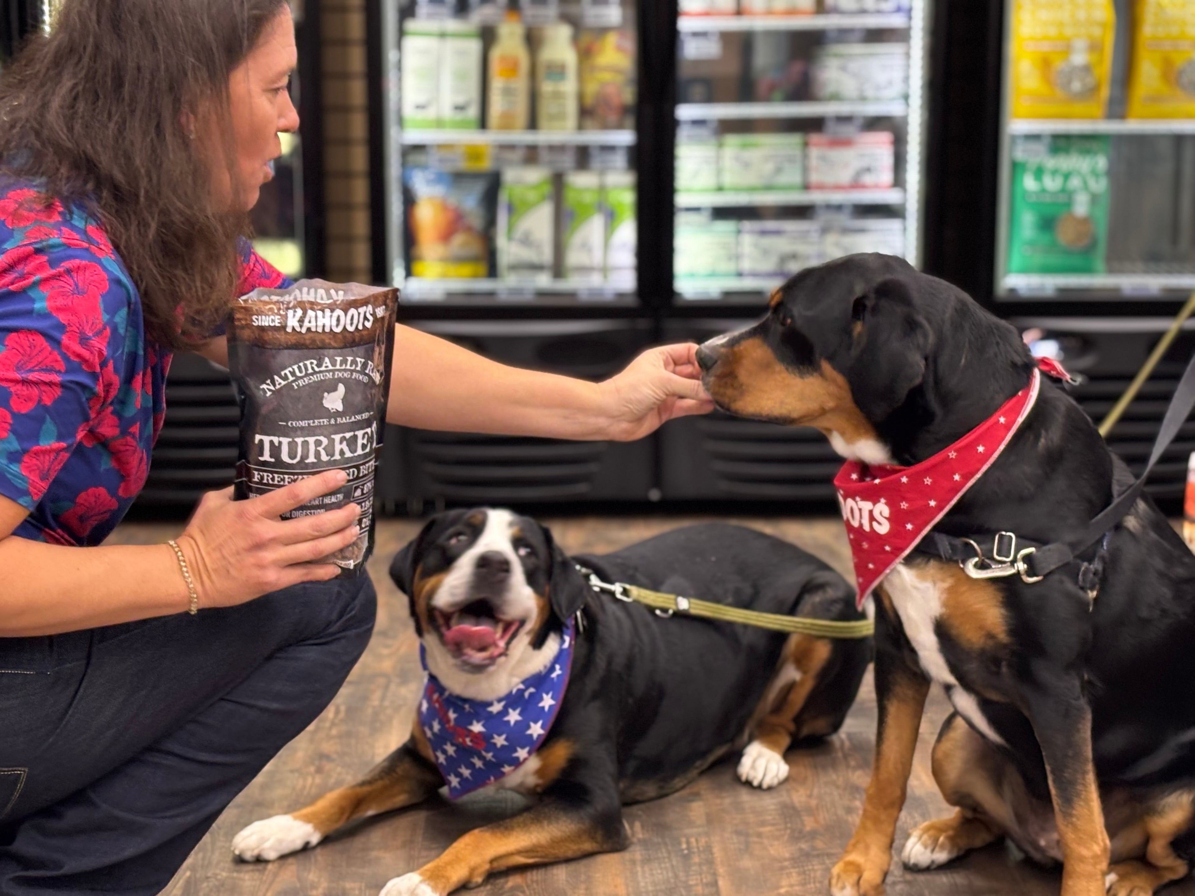 Woman feeding two dogs in a Kahoots store