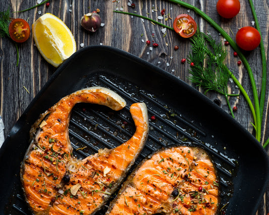 Grilled salmon in cast iron pan on wooden table