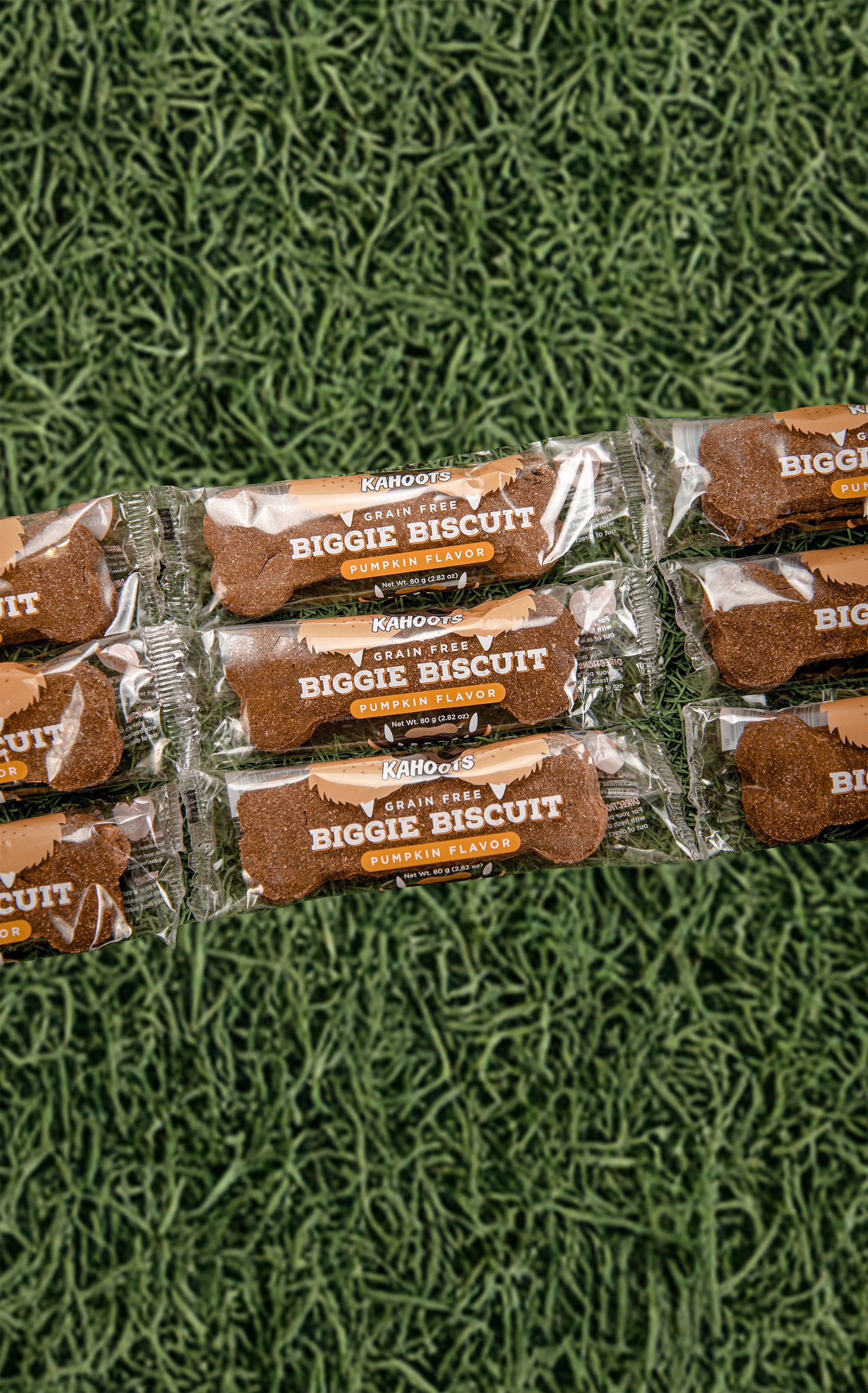 Multiple packages of Biggie Biscuit on a green textured surface