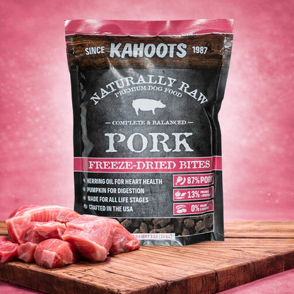 Kahoots pork freeze-dried bites packaging on a pink background with raw pork pieces.