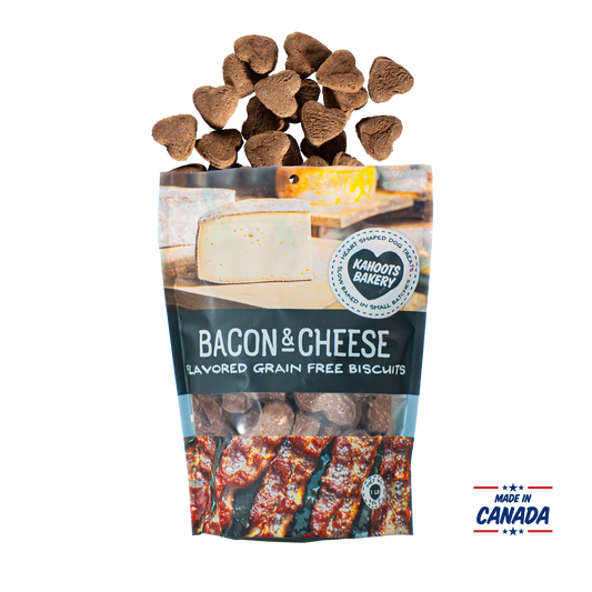 Grain free, heart-shaped bacon and cheese flavored dog biscuits pouring out of bag