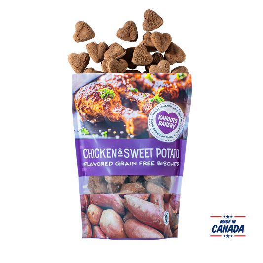 Grain free, heart-shaped chicken and sweet potato flavored dog biscuits pouring out of bag