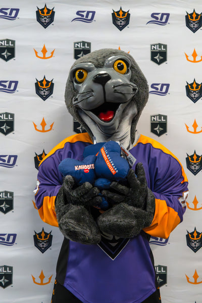 Seal mascot holding Kahoots heart plushie toys